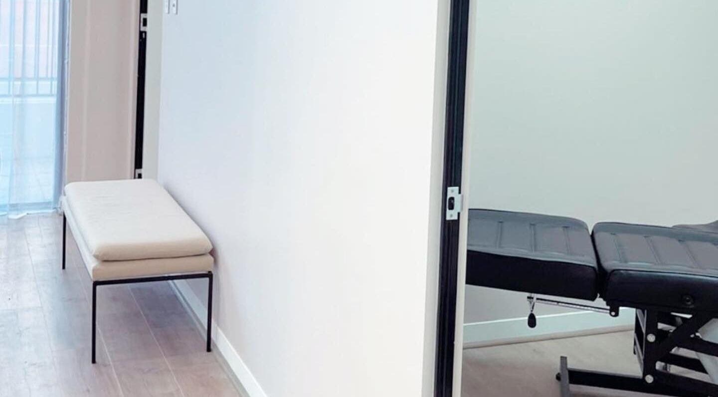 A tranquil treatment room at Haus of Arches, Bicton, Western Australia, AU with a massage table and seating.