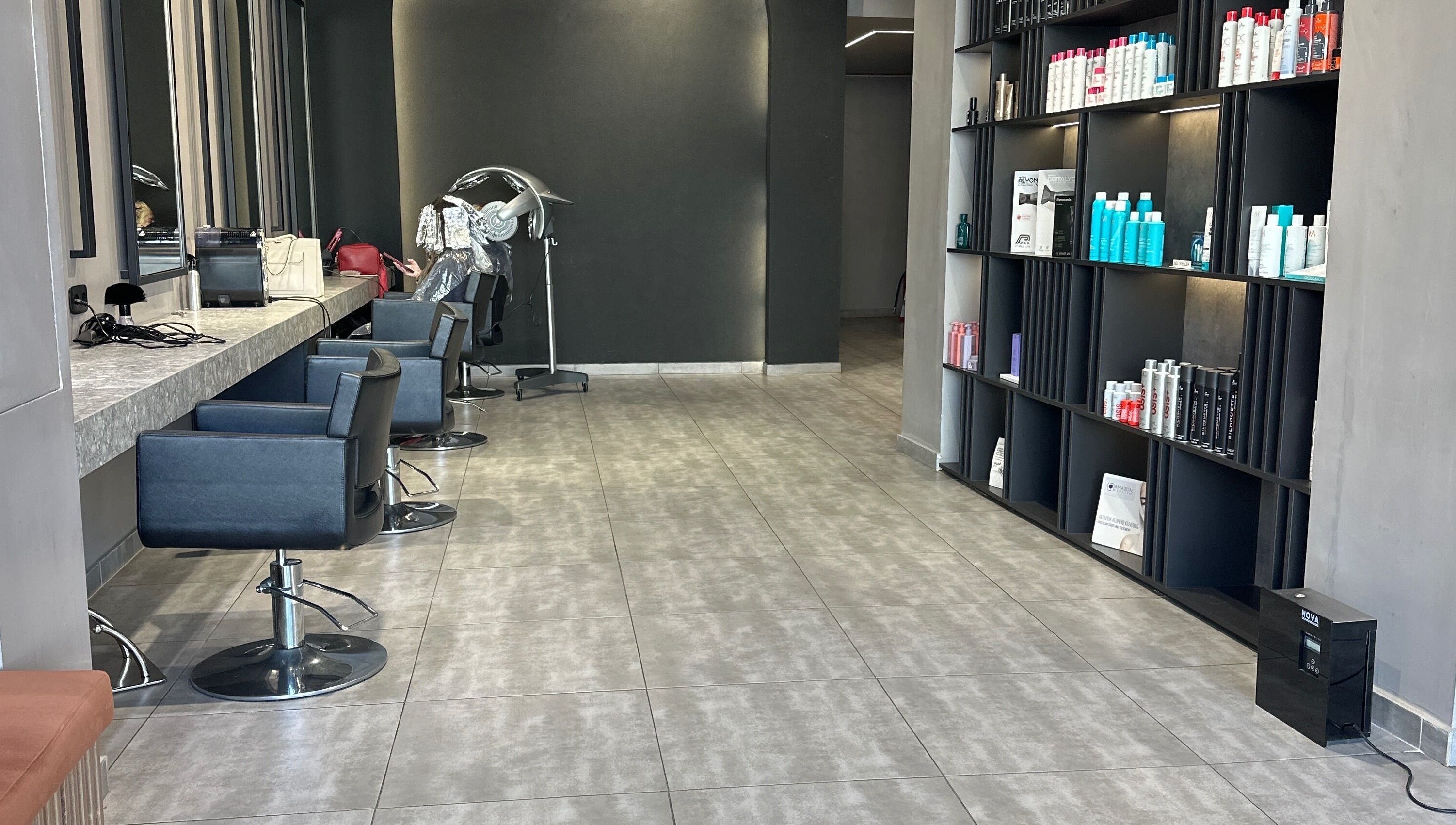 Σαλόνι ομορφιάς Klimishairlounge στη Νέα Αλικαρνασσό, GR με κομψά καθίσματα και προϊόντα περιποίησης μαλλιών.