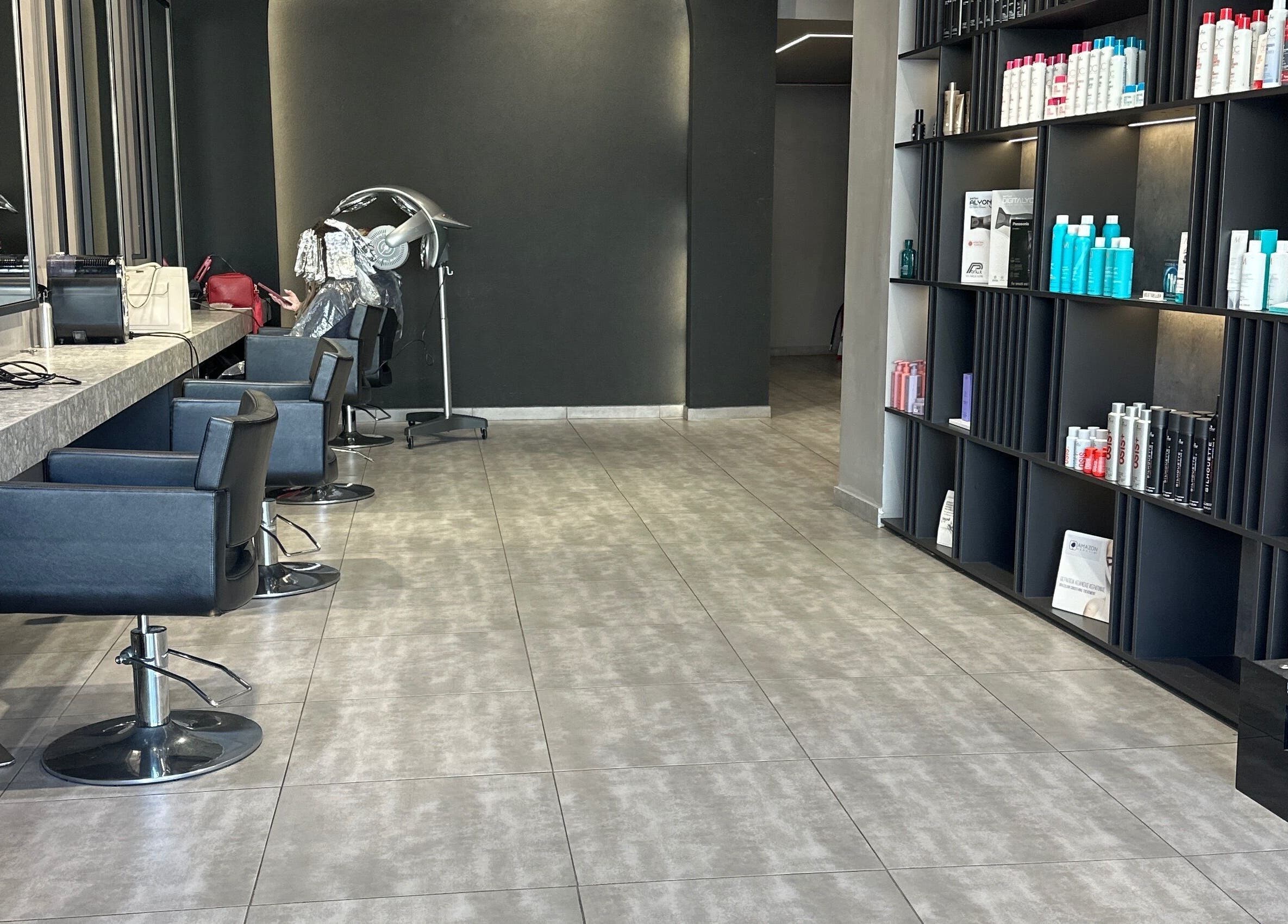 Σαλόνι ομορφιάς Klimishairlounge στη Νέα Αλικαρνασσό, GR με κομψά καθίσματα και προϊόντα περιποίησης μαλλιών.