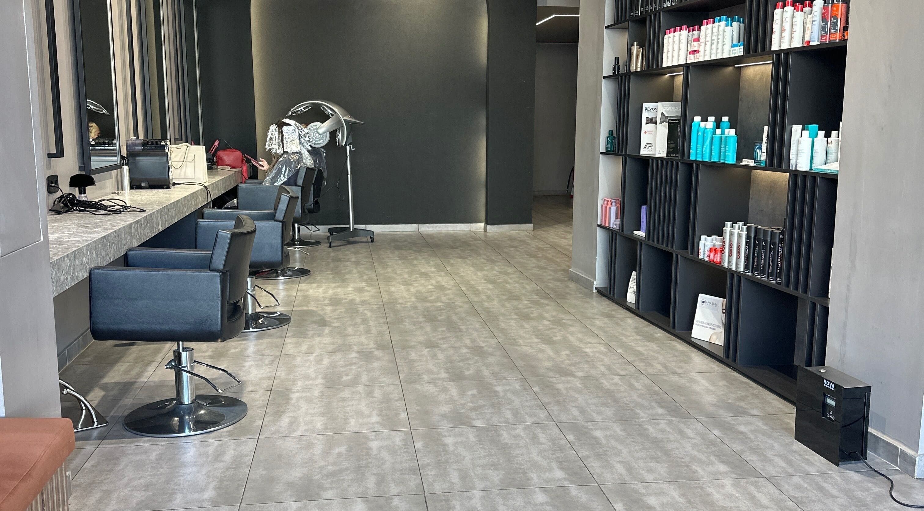 Σαλόνι ομορφιάς Klimishairlounge στη Νέα Αλικαρνασσό, GR με κομψά καθίσματα και προϊόντα περιποίησης μαλλιών.