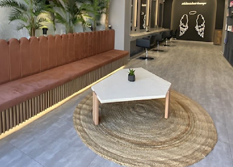 Κομψό εσωτερικό του Klimishairlounge, Nea Alikarnassos, GR με καναπέ και τραπέζι.