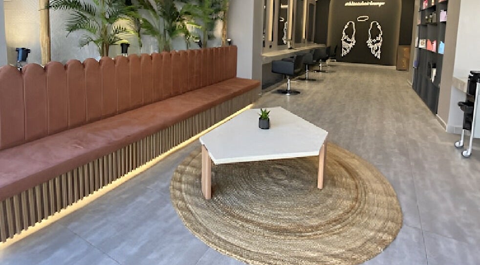 Κομψό εσωτερικό του Klimishairlounge, Nea Alikarnassos, GR με καναπέ και τραπέζι.