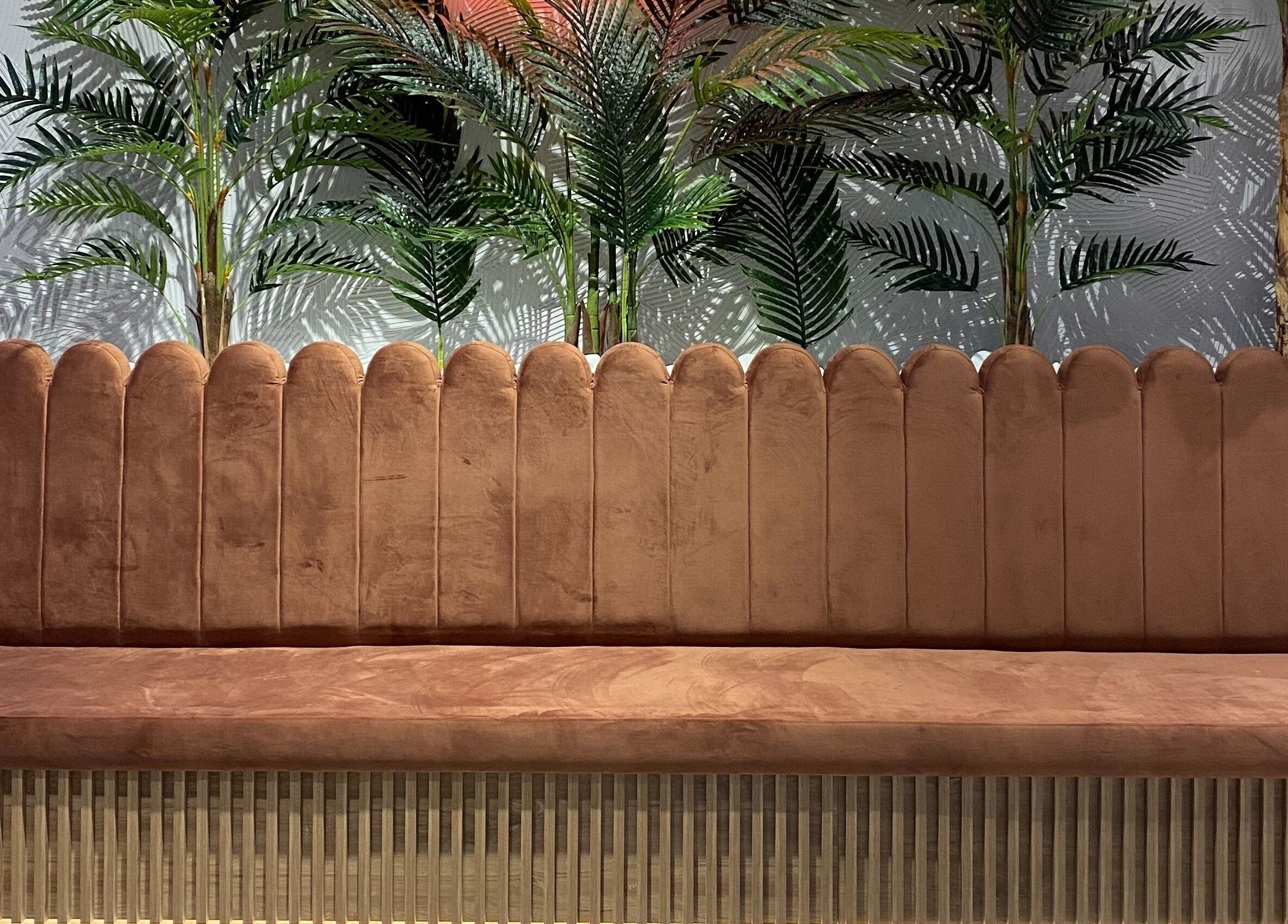 Κομψός καναπές στο Klimishairlounge, Νέα Αλικαρνασσός, GR με φόντο πράσινα φυτά.