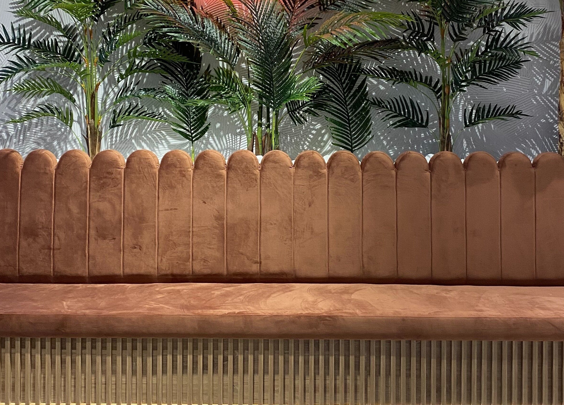 Κομψός καναπές στο Klimishairlounge, Νέα Αλικαρνασσός, GR με φόντο πράσινα φυτά.