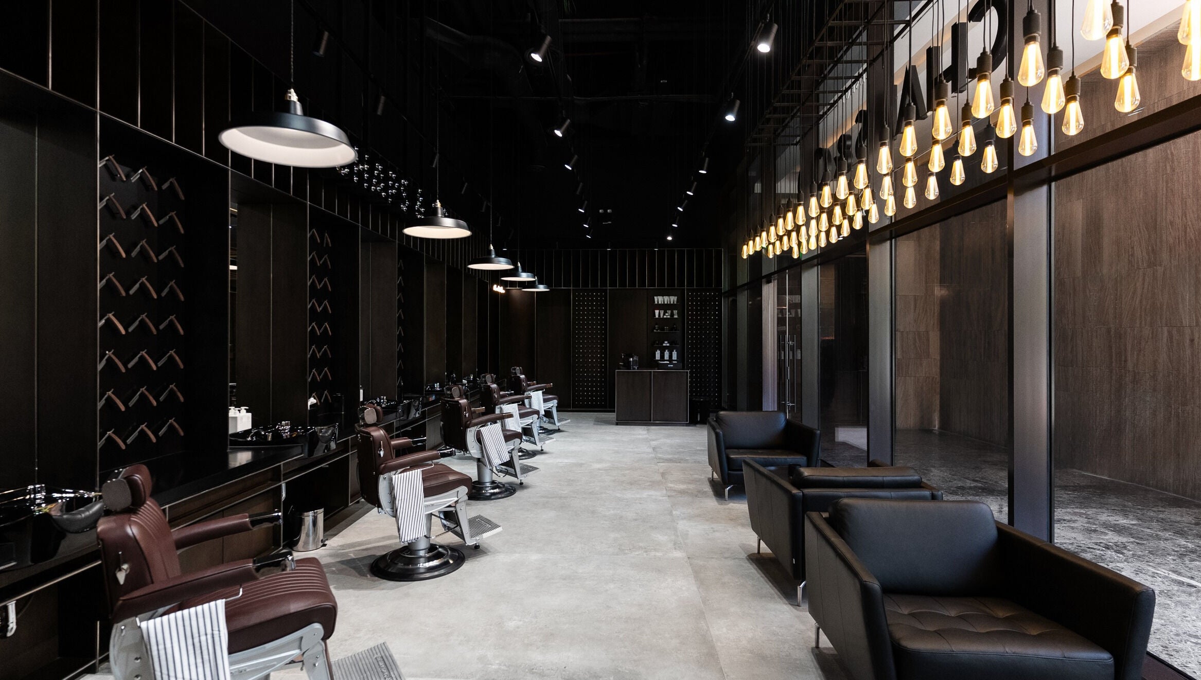 Luxurious interior of Chaps & Co - VIA Riyadh, Riyadh, featuring stylish barber chairs and lighting.