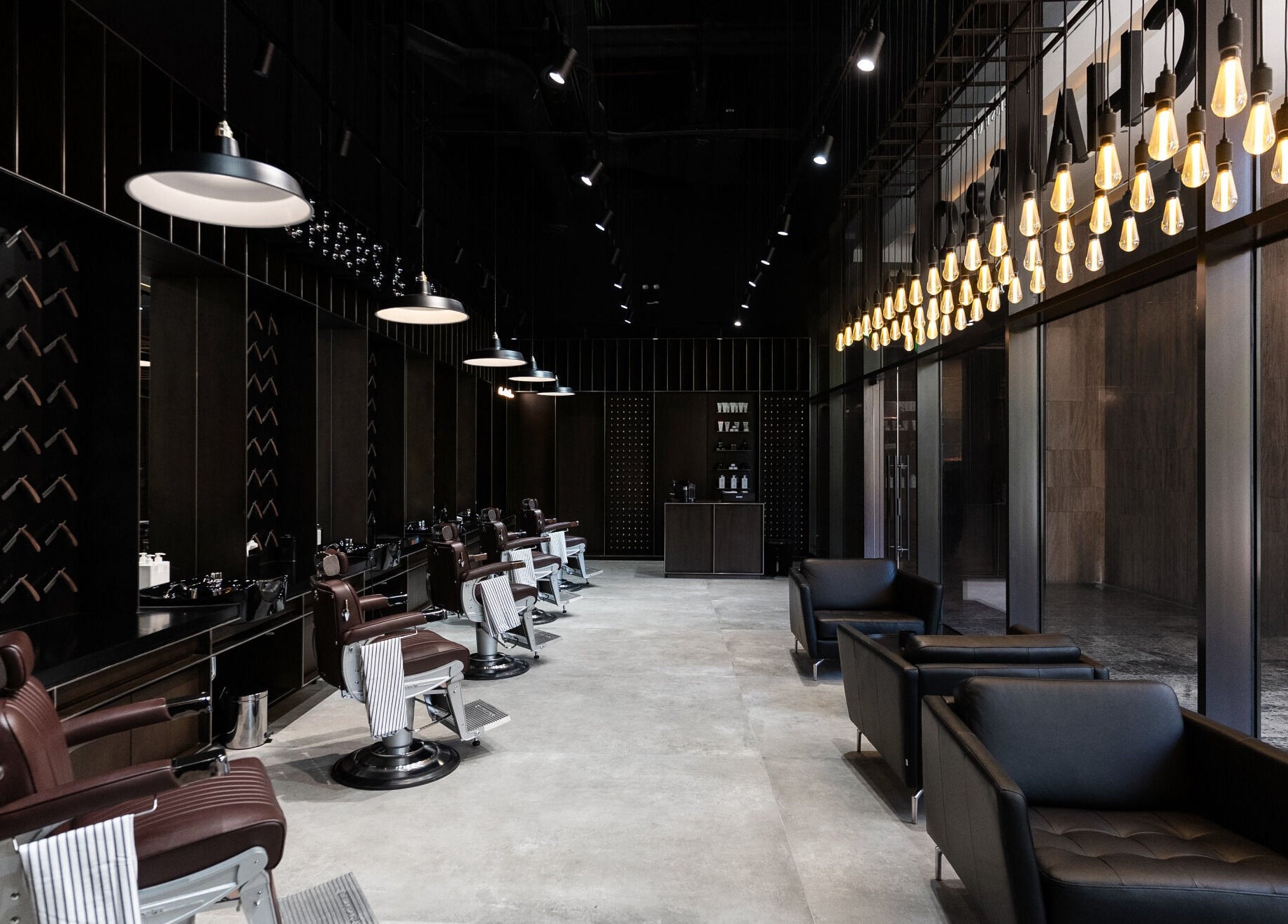 Luxurious interior of Chaps & Co - VIA Riyadh, Riyadh, featuring stylish barber chairs and lighting.