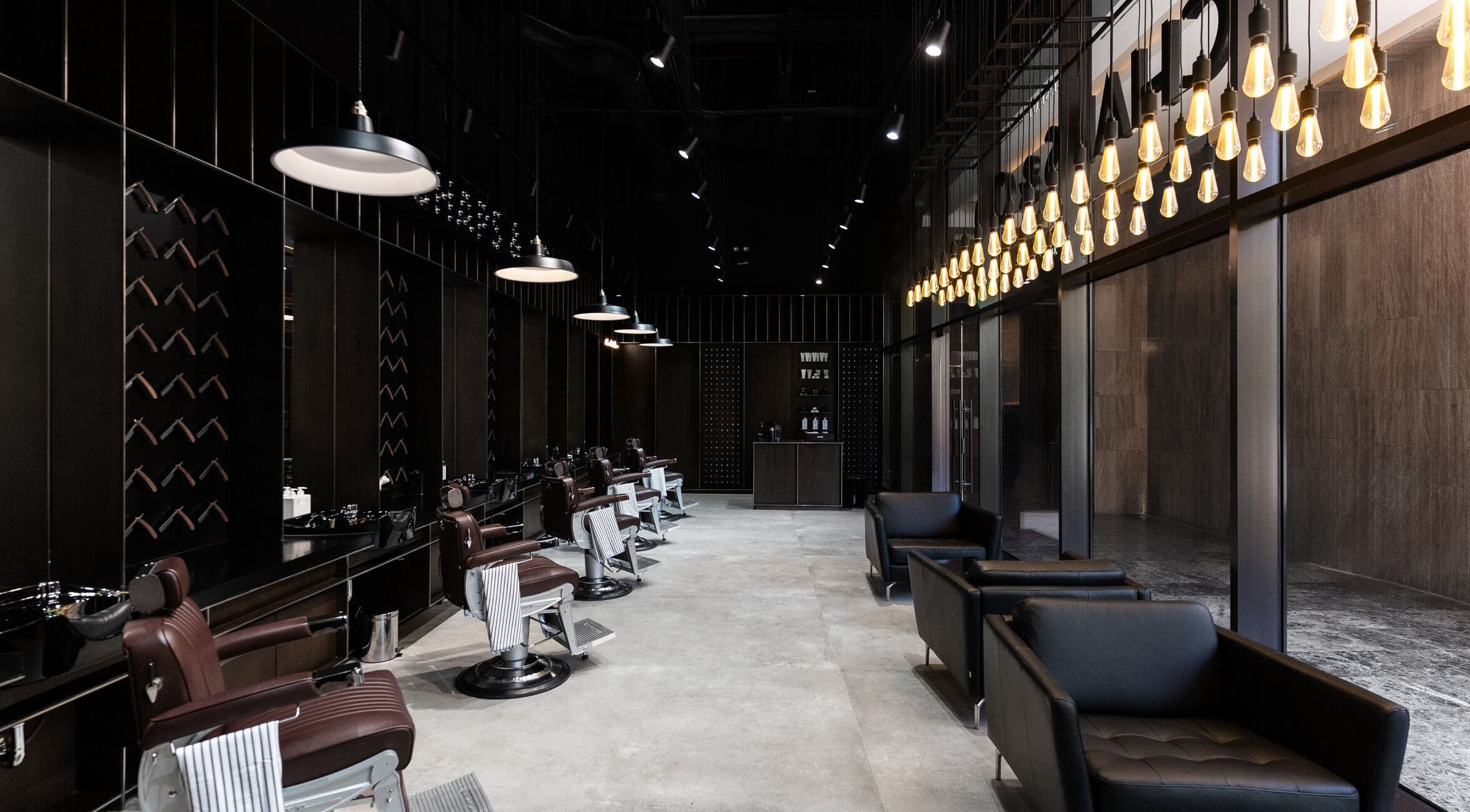 Luxurious interior of Chaps & Co - VIA Riyadh, Riyadh, featuring stylish barber chairs and lighting.
