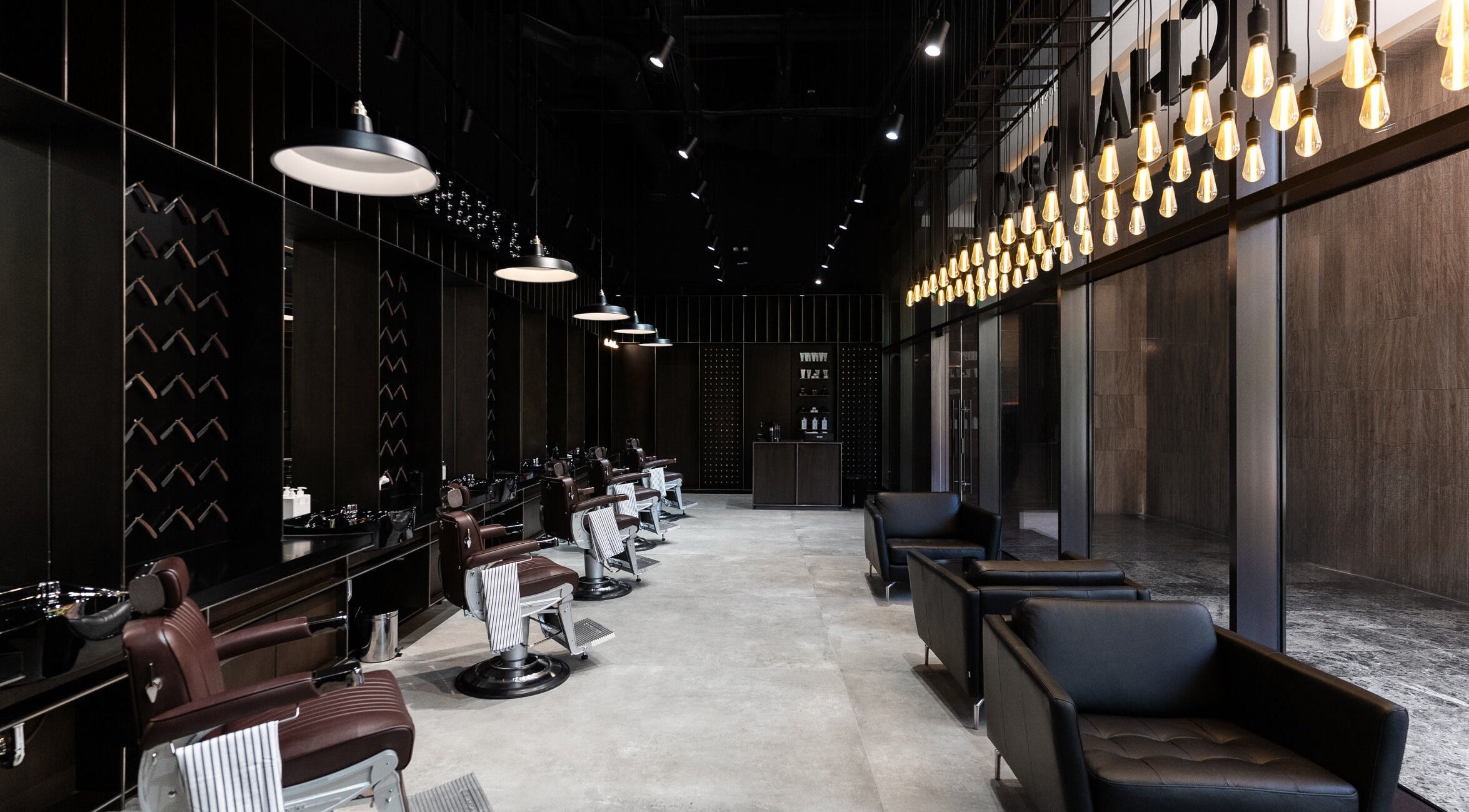 Luxurious interior of Chaps & Co - VIA Riyadh, Riyadh, featuring stylish barber chairs and lighting.