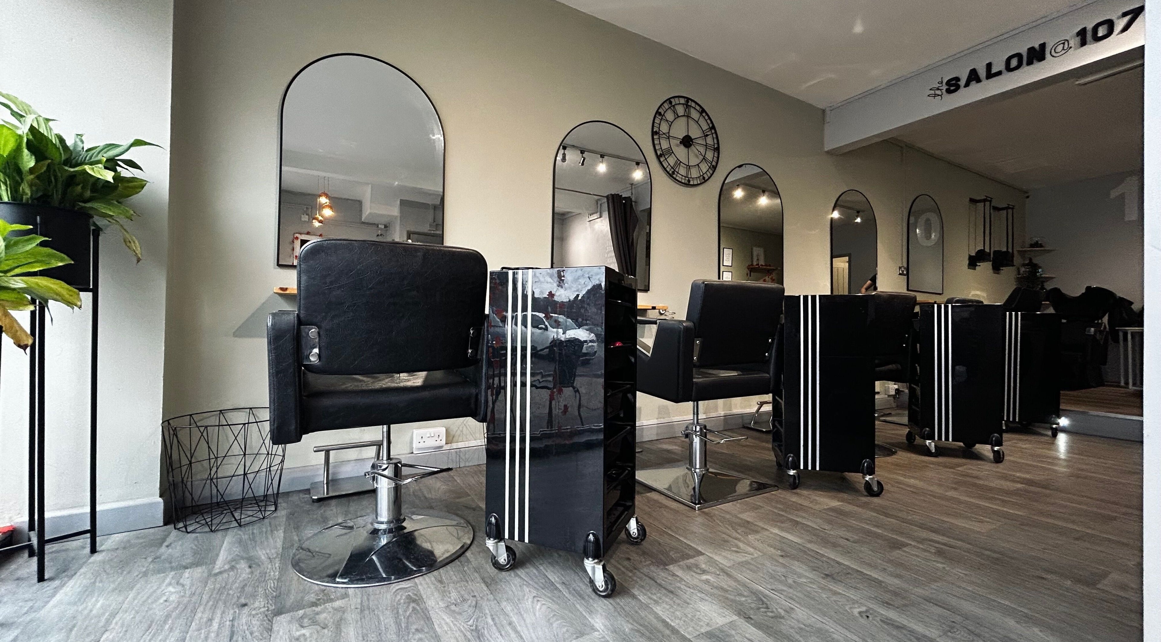 Modern interior of The Salon @ 107 in Braunstone Town, England, GB with sleek styling chairs and mirrors.