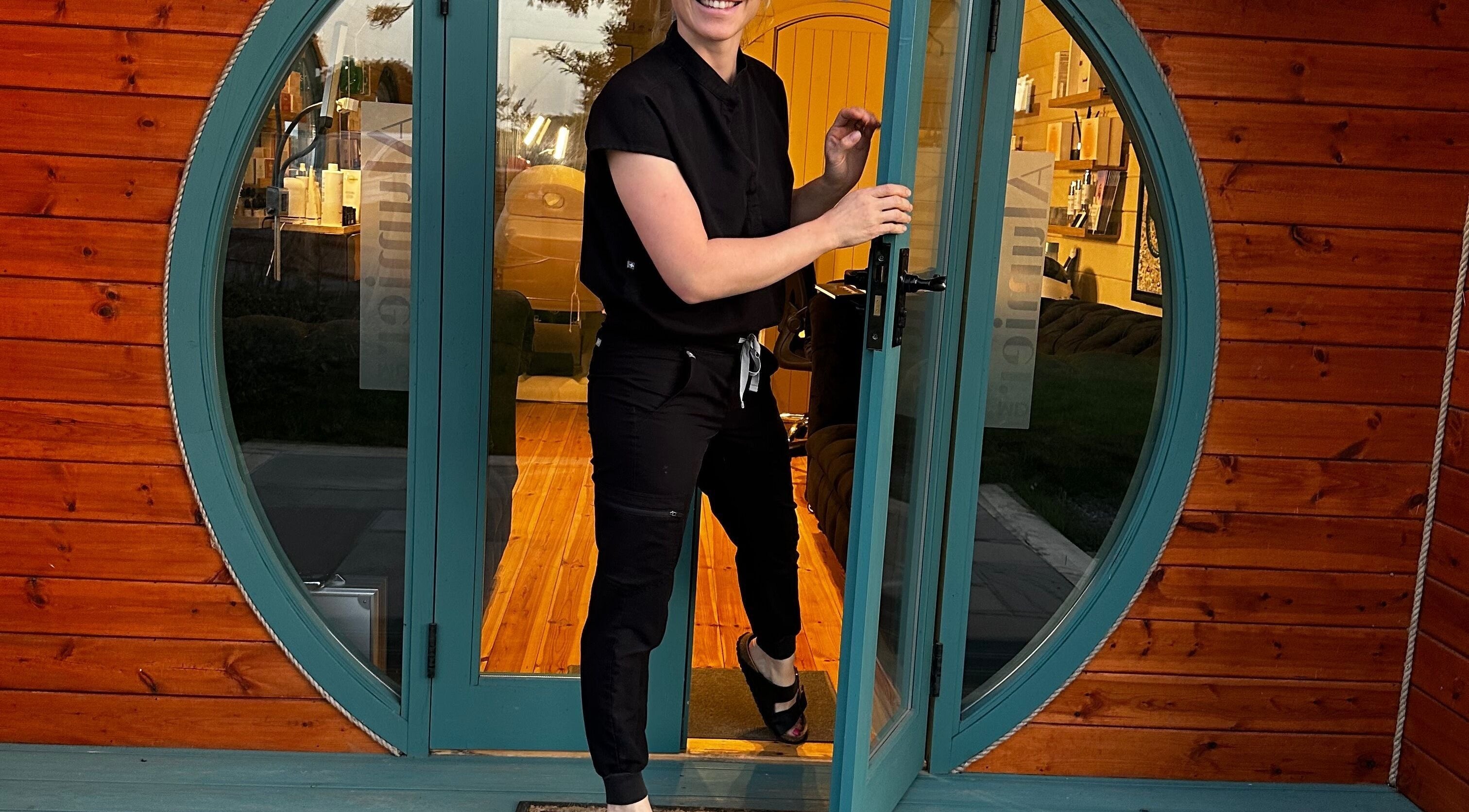 Smiling staff member opens the round green door at Sophie Rae Medical, Dover in Guston, England, GB.