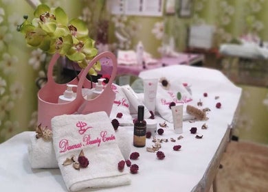 Luxurious spa setup at Damas Beauty Group - Al Mirgab, Sharjah, AE, featuring plush towels and skincare products.