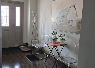 Welcoming entrance at Loosen Up, Cambridge, Ontario, CA with clear chairs, table, and wall art.
