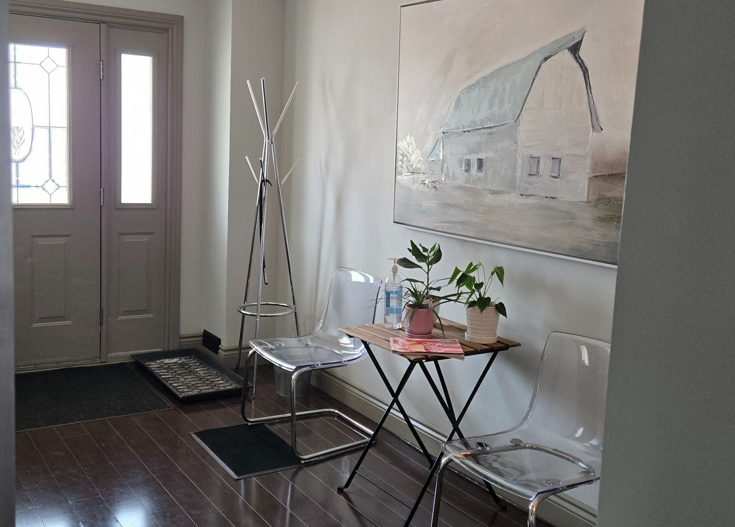 Welcoming entrance at Loosen Up, Cambridge, Ontario, CA with clear chairs, table, and wall art.