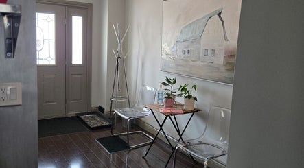Welcoming entrance at Loosen Up, Cambridge, Ontario, CA with clear chairs, table, and wall art.