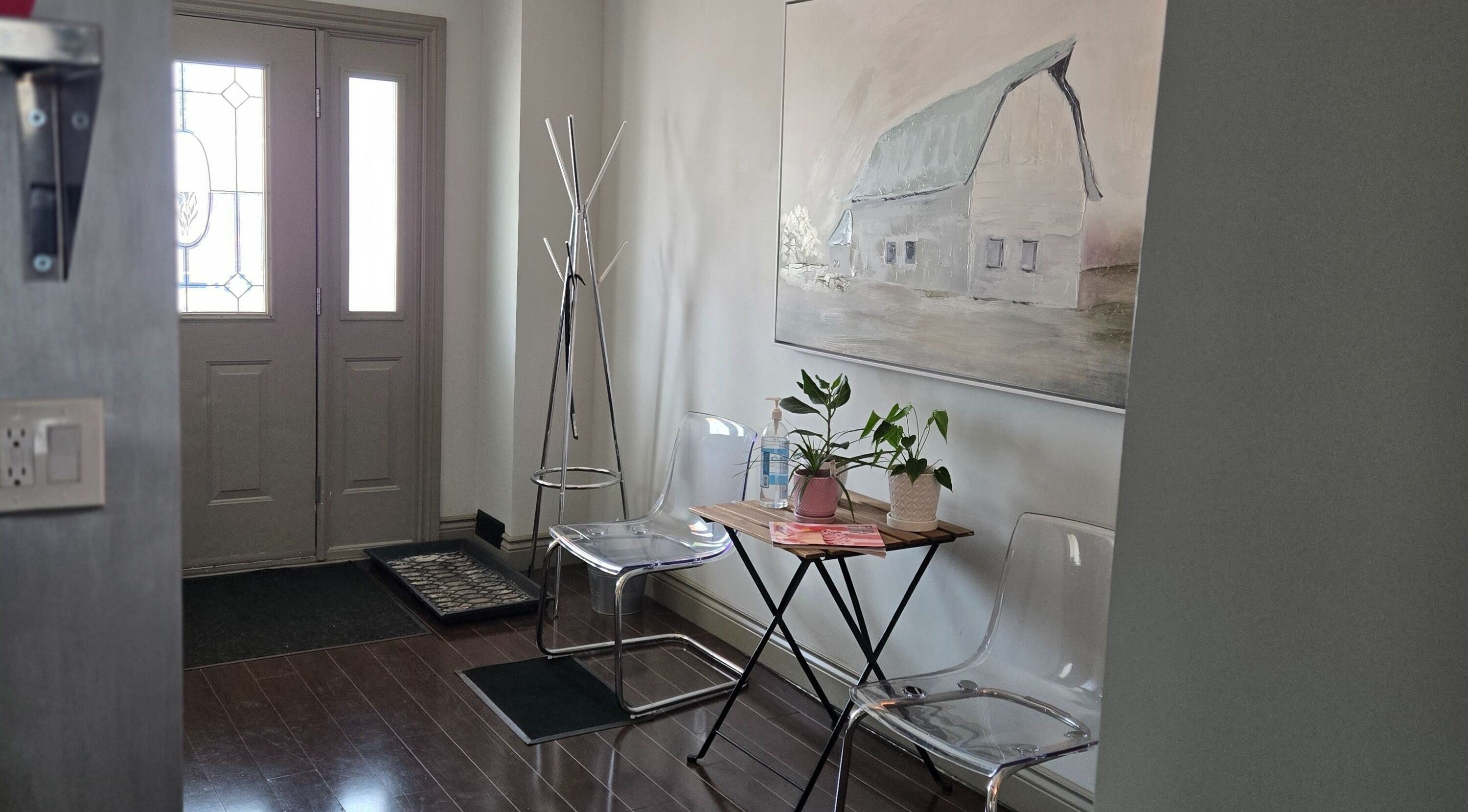 Welcoming entrance at Loosen Up, Cambridge, Ontario, CA with clear chairs, table, and wall art.