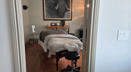 Relaxing massage room at Loosen Up, Cambridge, Ontario, CA with massage table and elephant art.