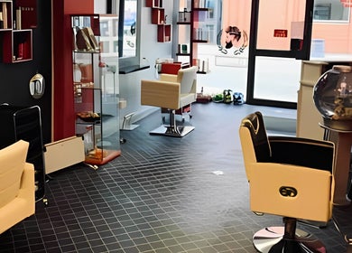 Modern salon interior at Fuzion Hair & Beauty Zone, Stonehouse, England, GB with stylish chairs and decor.