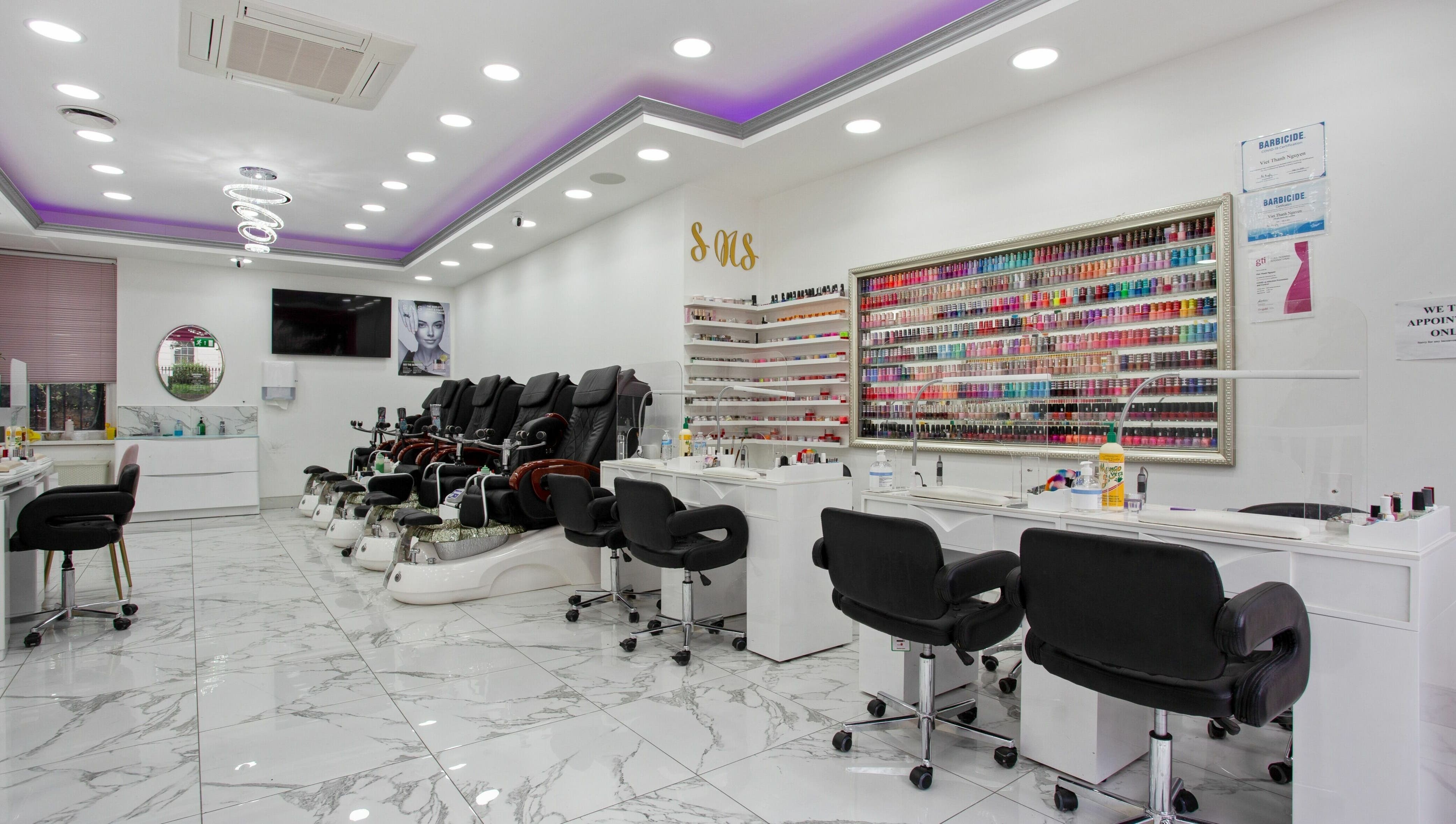 Inside Haus of Colours, London, England, GB: a vibrant nail salon with chic seating and a wide array of nail polishes.