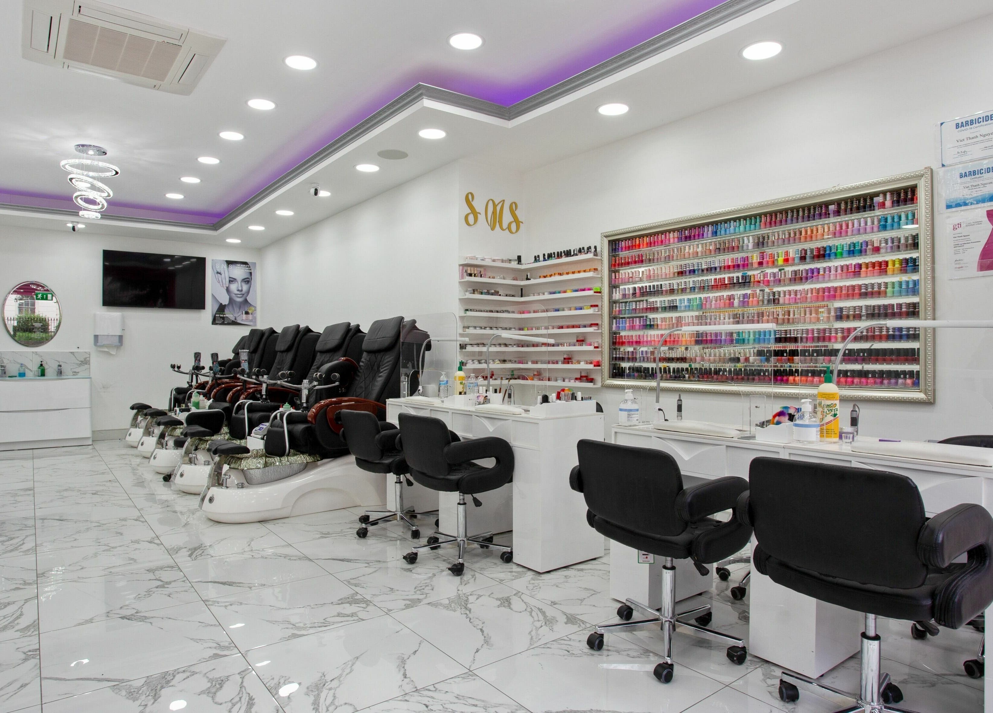 Inside Haus of Colours, London, England, GB: a vibrant nail salon with chic seating and a wide array of nail polishes.