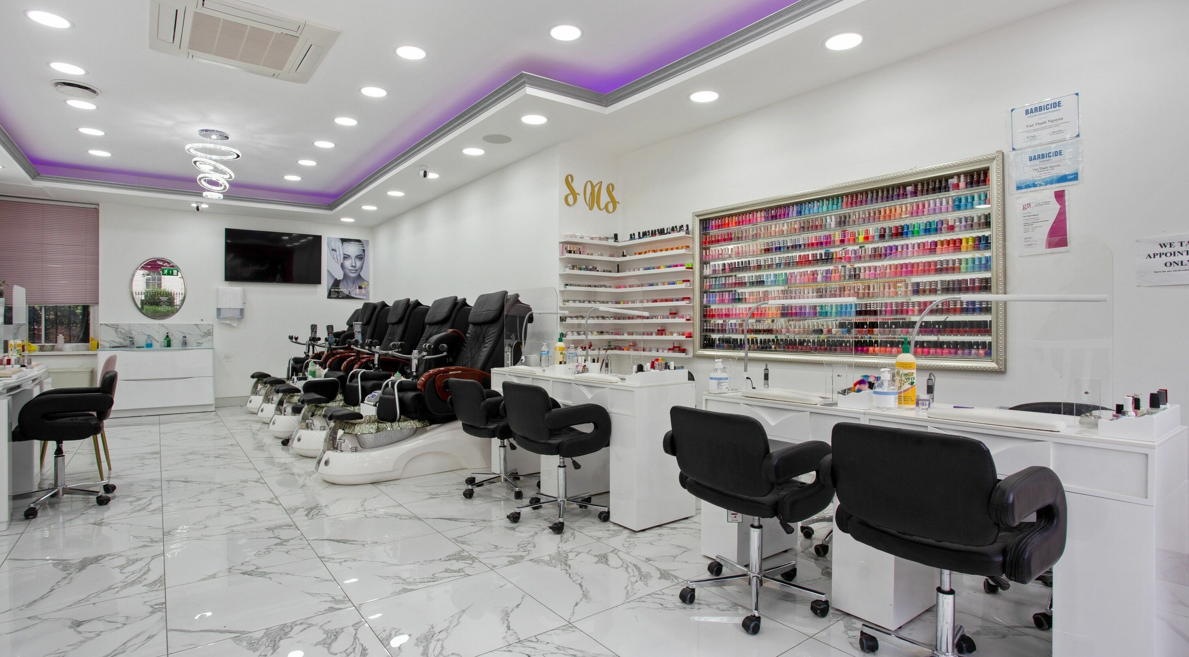 Inside Haus of Colours, London, England, GB: a vibrant nail salon with chic seating and a wide array of nail polishes.