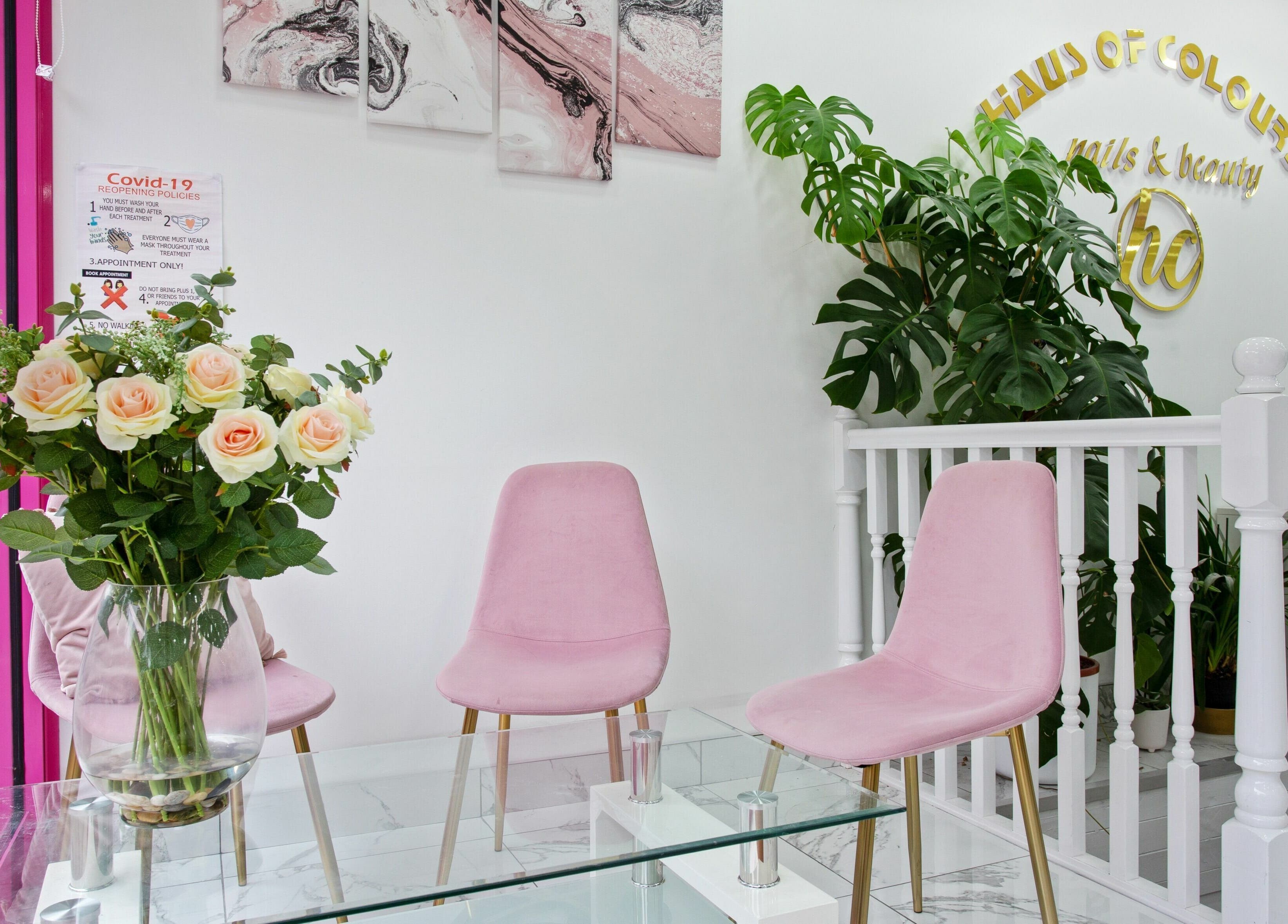 Elegant seating with pink chairs at Haus of Colours, London, England. Stylish decor with plants and art.