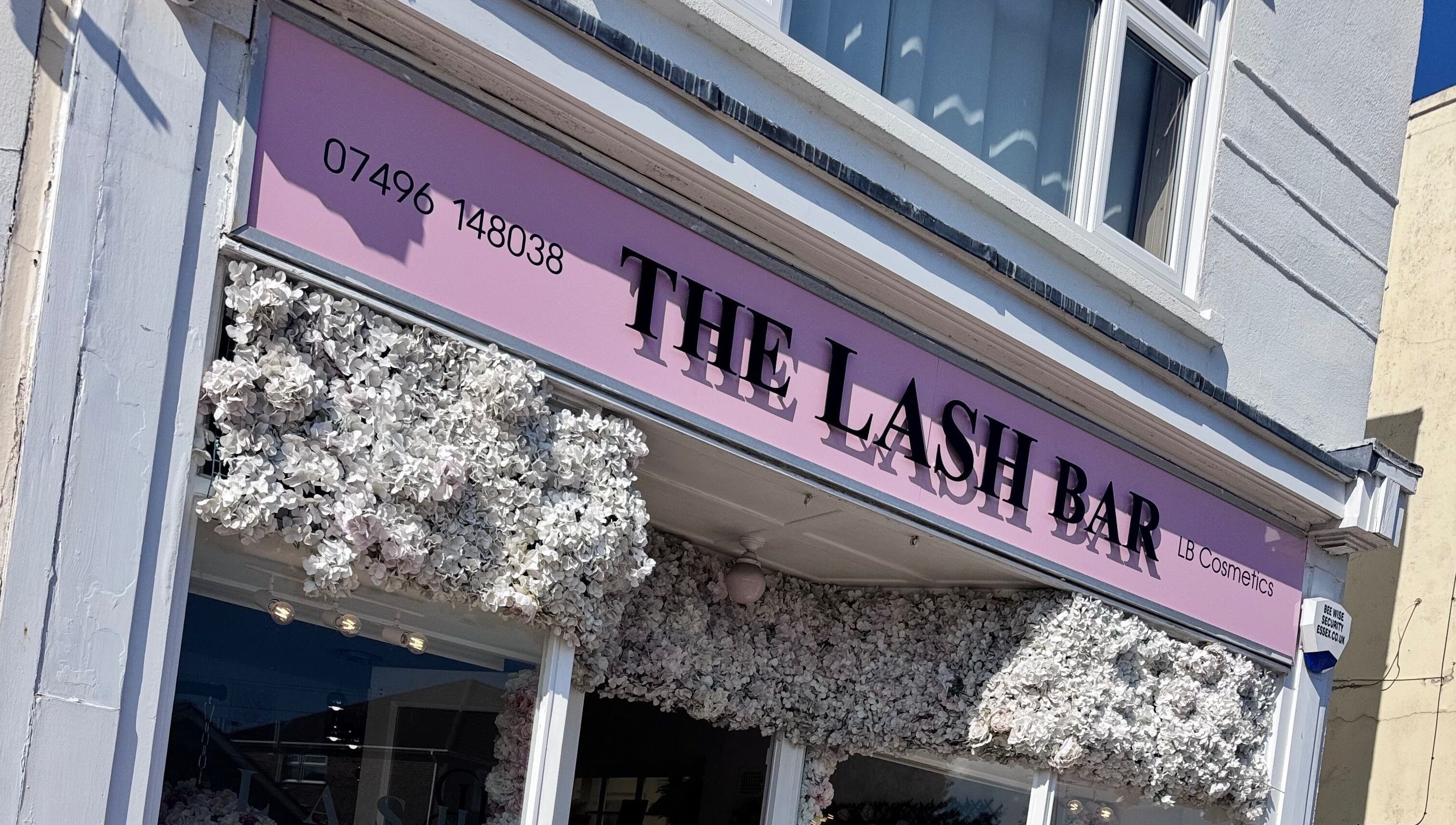 The Lash Bar storefront adorned with white flowers in Holland-on-sea, England, GB.