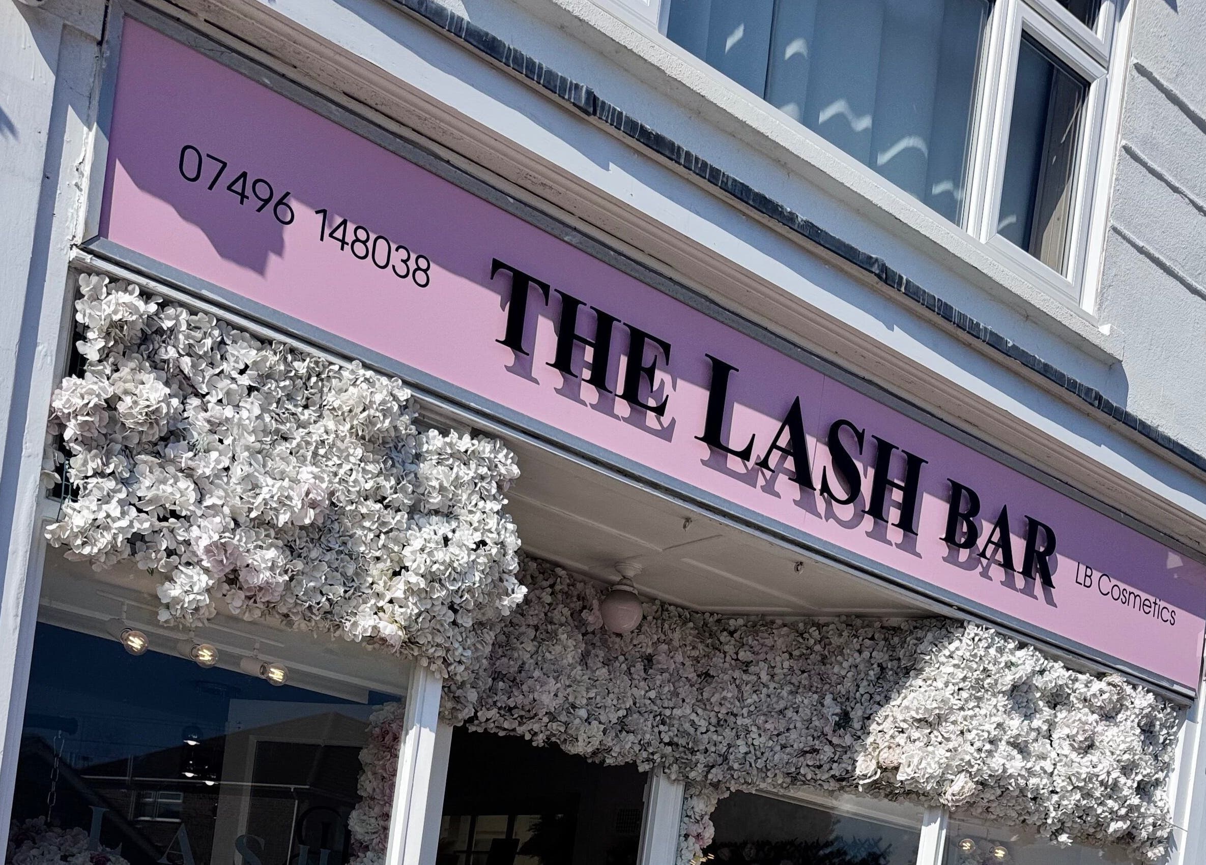 The Lash Bar storefront adorned with white flowers in Holland-on-sea, England, GB.