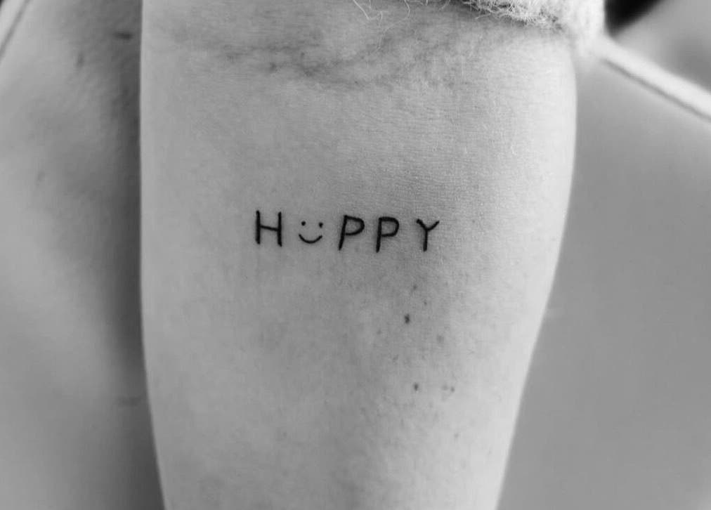 Minimalist 'Happy' tattoo at The Lash Bar, Holland-on-sea, England, GB showcasing unique artistic style.