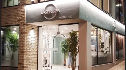 Μοντέρνα πρόσοψη του Laser Spa στην Ιωάννινα, GR με κομψό φωτισμό και πράσινα φυτά.