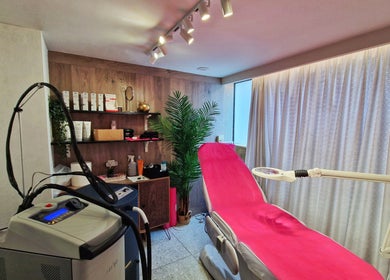 Δωμάτιο θεραπείας στο Laser Spa, Ιωάννινα, GR με ροζ κρεβάτι και εξοπλισμό αισθητικής.