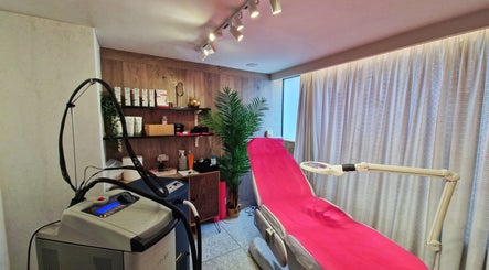 Δωμάτιο θεραπείας στο Laser Spa, Ιωάννινα, GR με ροζ κρεβάτι και εξοπλισμό αισθητικής.