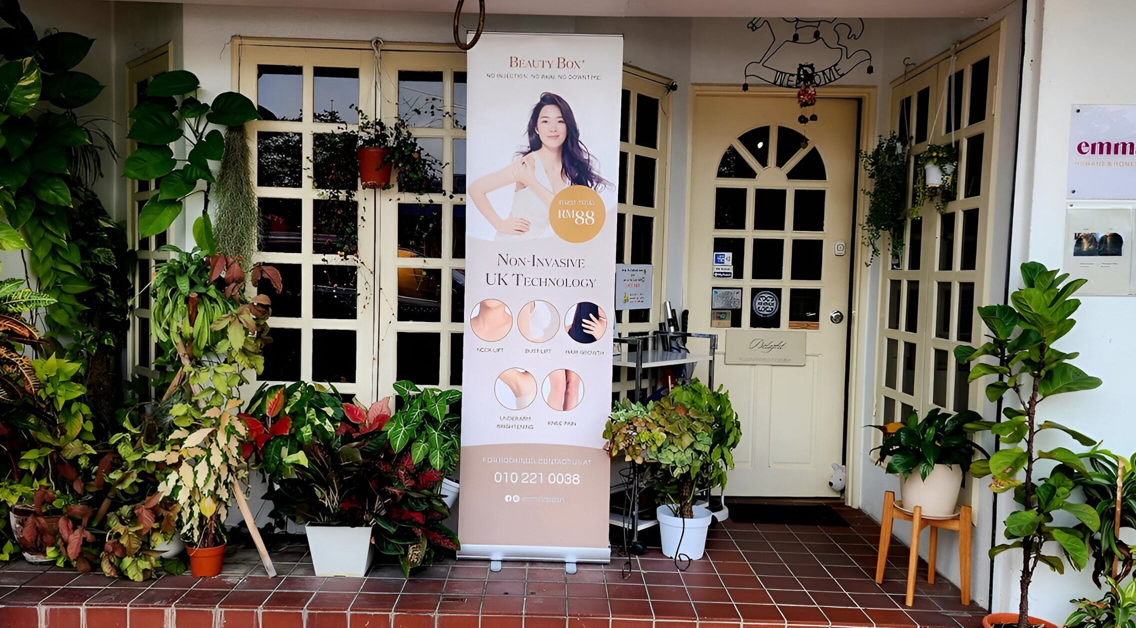 Entrance of Emma Lizs Subang Jaya adorned with lush plants and wellness banner in Subang Jaya, Selangor, MY.