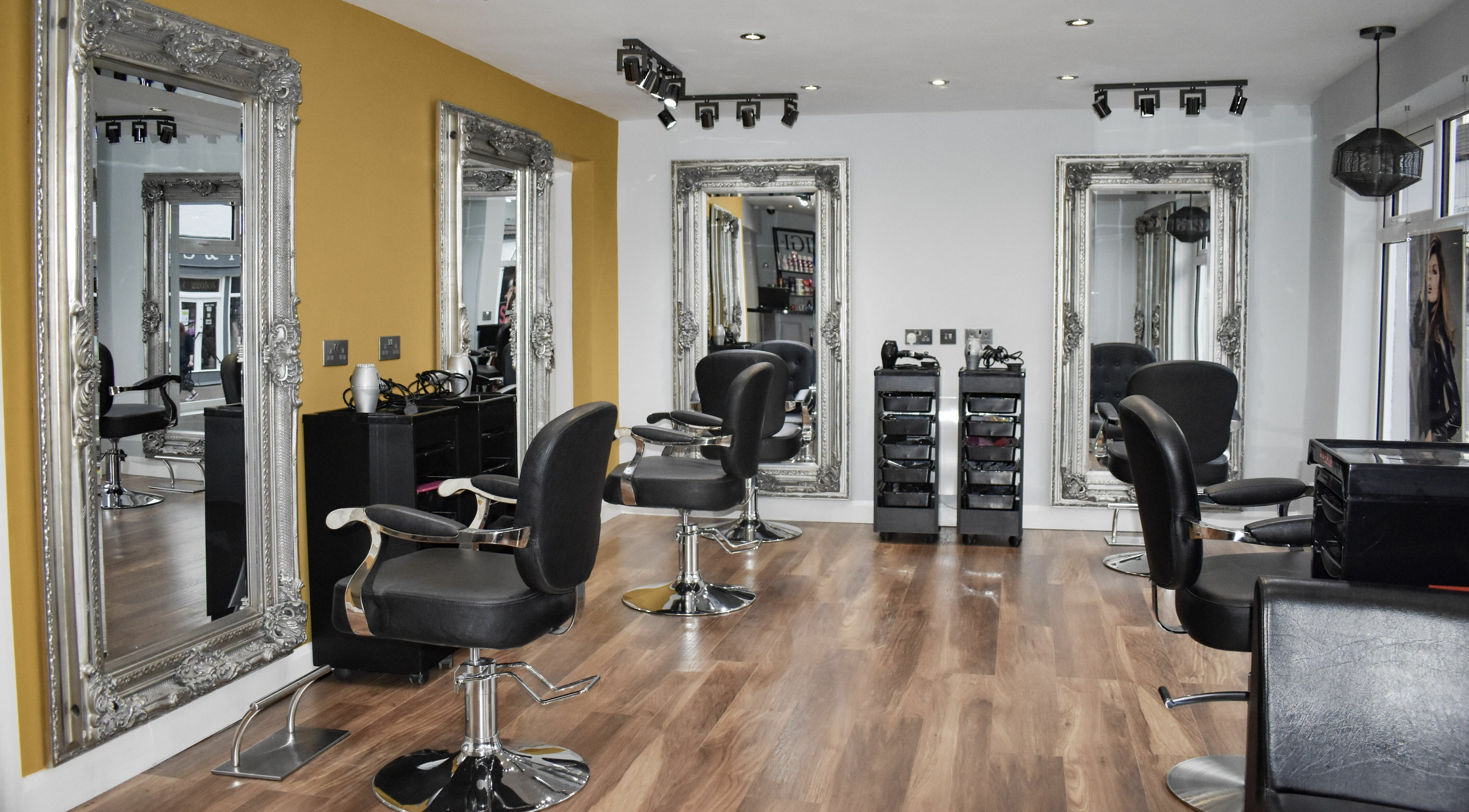Stylish interior of The Hair Gallery, Waltham, England, GB with chic mirrors and salon chairs.