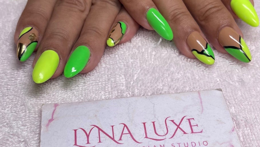 Neon and gold nail art at Lyna Luxe in Bridgetown, BB showcasing intricate design and vibrant colors.