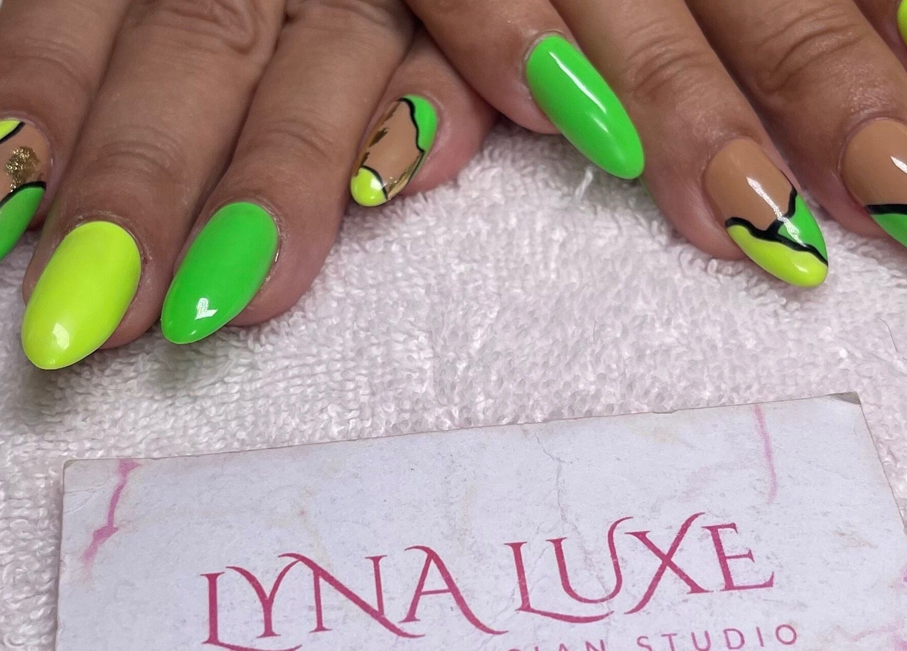 Neon and gold nail art at Lyna Luxe in Bridgetown, BB showcasing intricate design and vibrant colors.