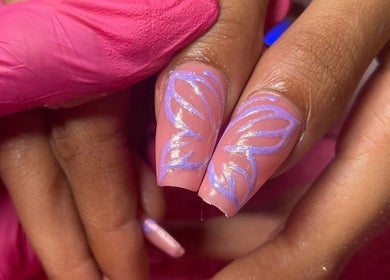 Stylish butterfly nail art at Lyna Luxe, Bridgetown, BB enhances beauty with delicate purple design.