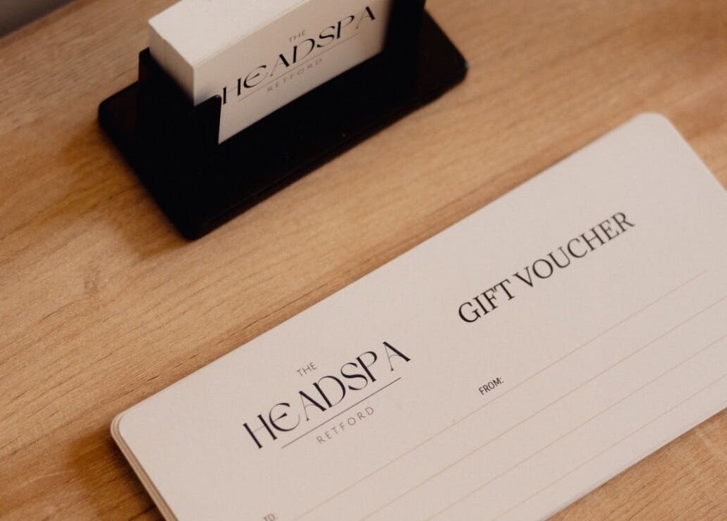 Elegant gift voucher from The Head Spa Retford LTD, Retford, England, GB displayed on wooden surface.