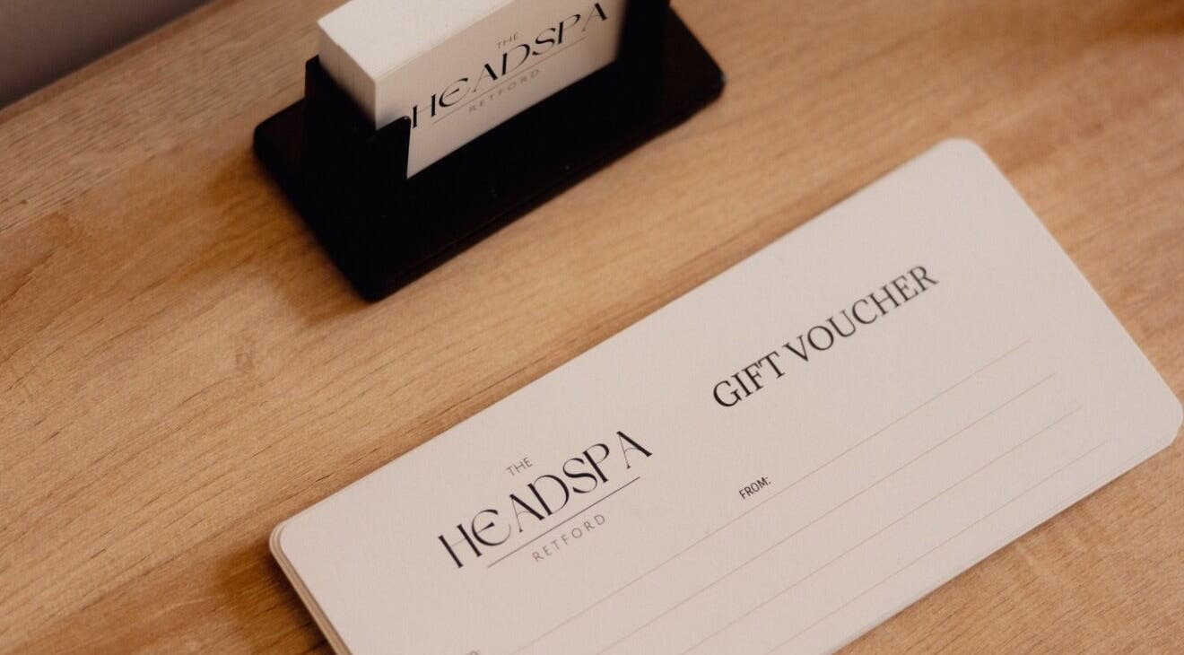 Elegant gift voucher from The Head Spa Retford LTD, Retford, England, GB displayed on wooden surface.