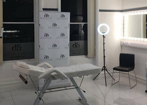 Bright treatment room at Reflect Aesthetics, Blackpool, England, GB showing a bed, mirrors, and lights.