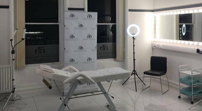 Bright treatment room at Reflect Aesthetics, Blackpool, England, GB showing a bed, mirrors, and lights.