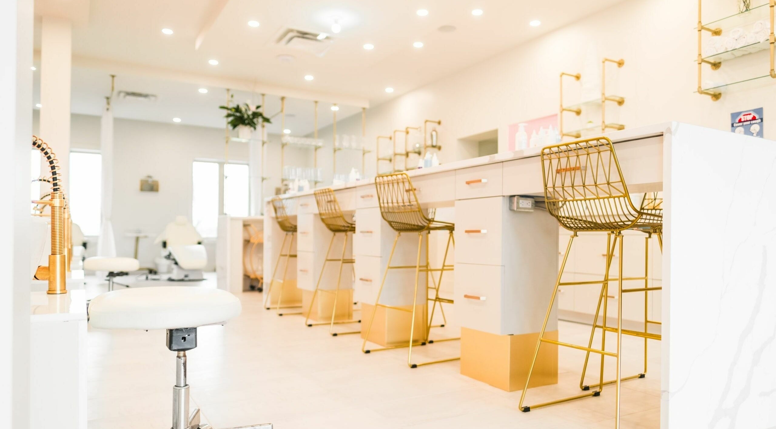 Elegant beauty lounge at Elixir Beauty Mixology in Niagara Falls, Ontario, CA, featuring chic gold accents.