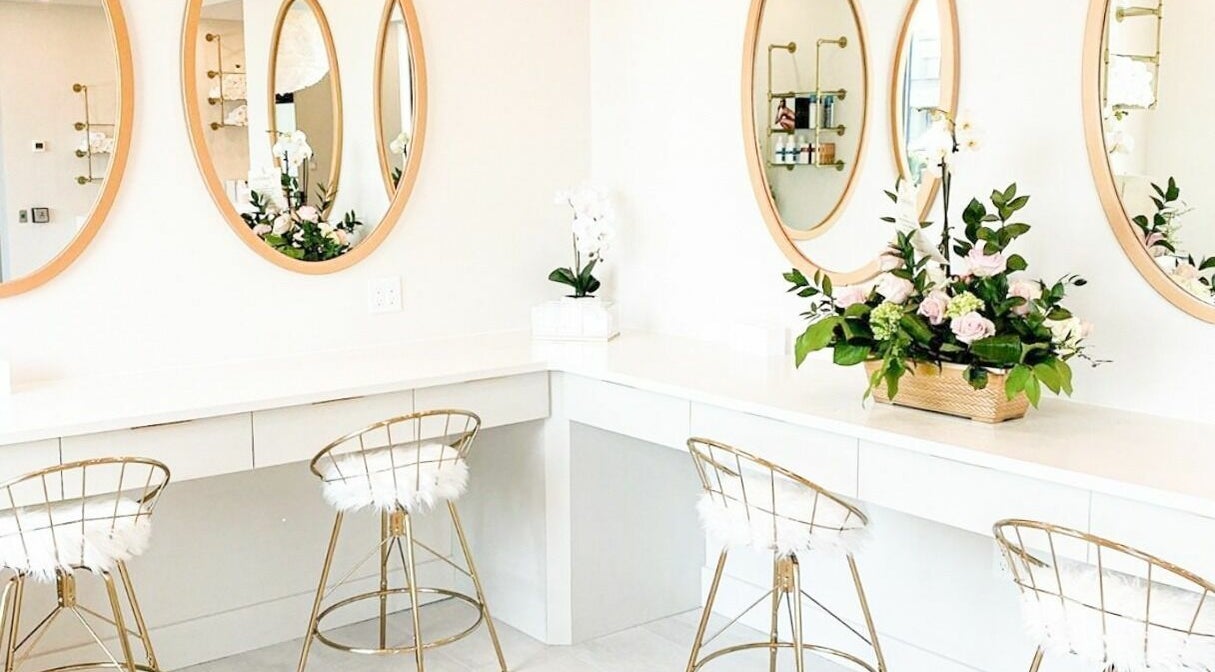 Sophisticated beauty setup at Elixir Beauty Mixology in Niagara Falls, Ontario, CA with elegant mirrors and flowers.