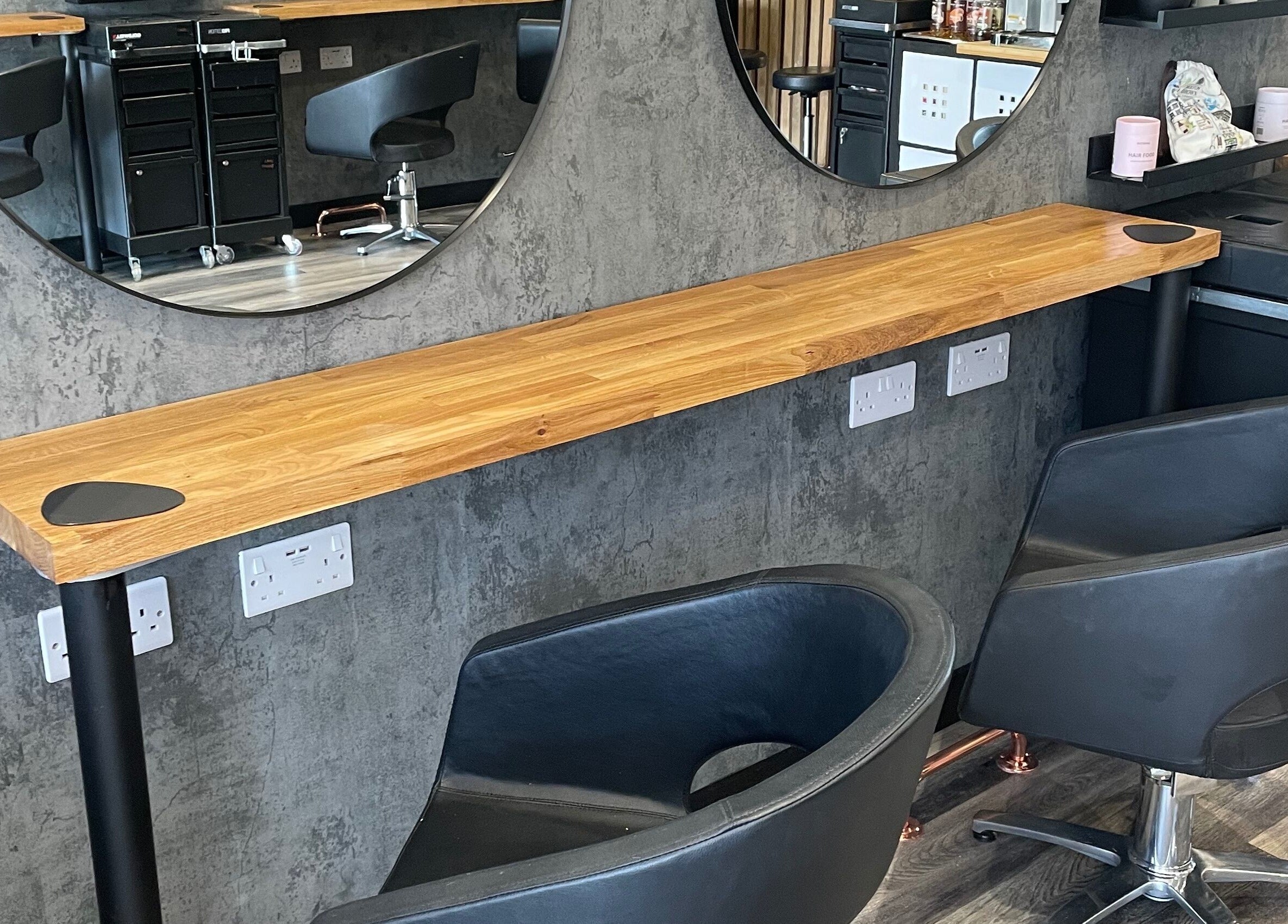 Modern styling chairs at BroDans Hair & Beauty Lounge, Cardiff, Wales, GB, with sleek mirrors and cozy seating.