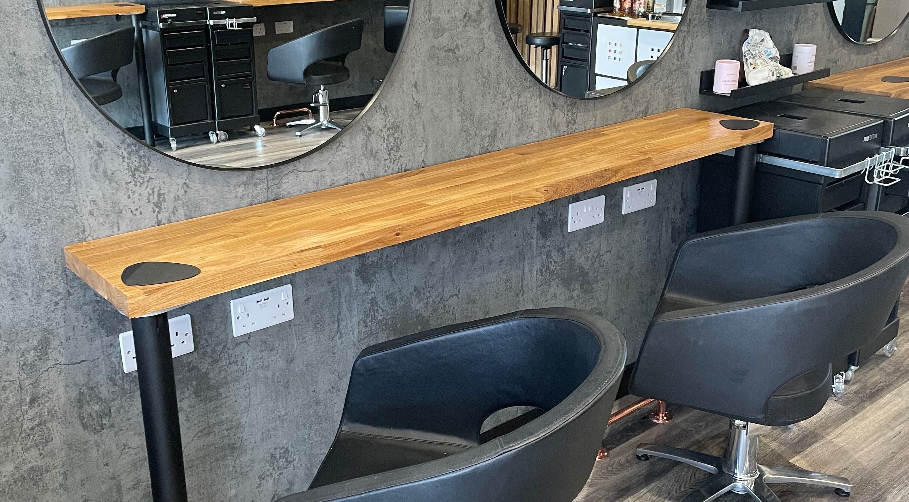 Modern styling chairs at BroDans Hair & Beauty Lounge, Cardiff, Wales, GB, with sleek mirrors and cozy seating.