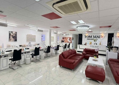 Innenraum von TomMai Nails&Beauty in Chur, Graubünden, CH mit roten Ledersofas und modernen Nageltischen.