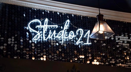 Glowing Studio 21 neon sign in Eckington, England, GB, on a stylish dark backdrop.