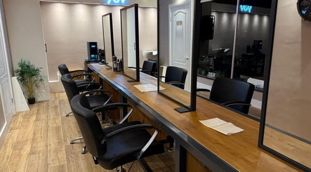 Elegant salon setup at Studio 21, Eckington, England, GB, with chairs and mirrors lining a wooden counter.