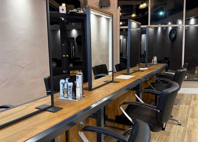 Modern styling stations at Studio 21, Eckington, England, GB, with sleek black chairs and illuminated mirrors.