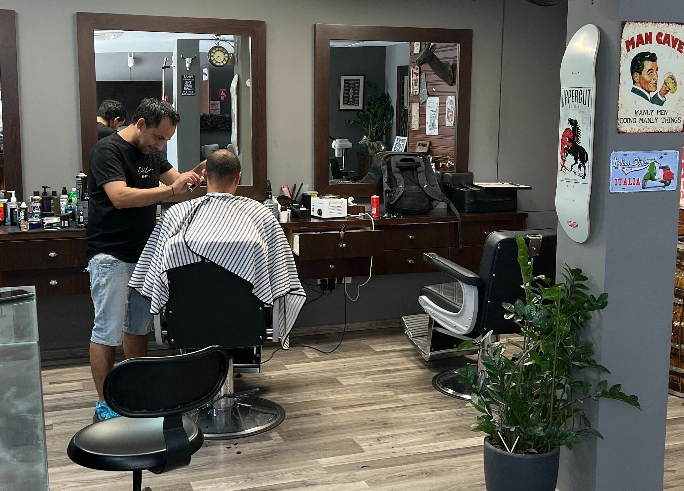 Mancave Barbershop in Limassol, CY features a stylist at work in a modern, vintage-themed interior.