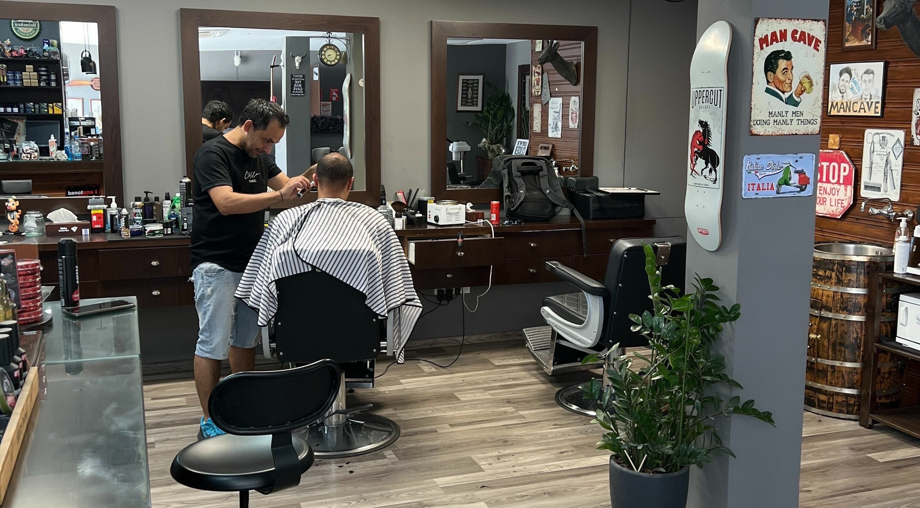 Mancave Barbershop in Limassol, CY features a stylist at work in a modern, vintage-themed interior.